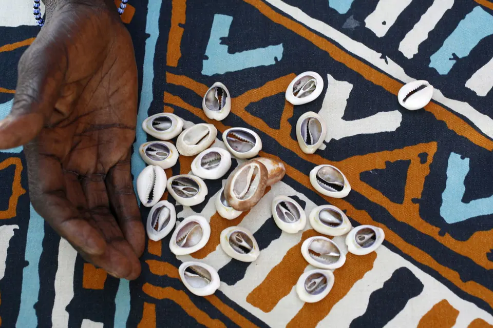 Cauris répandus sur un tissu wax aux motifs africains