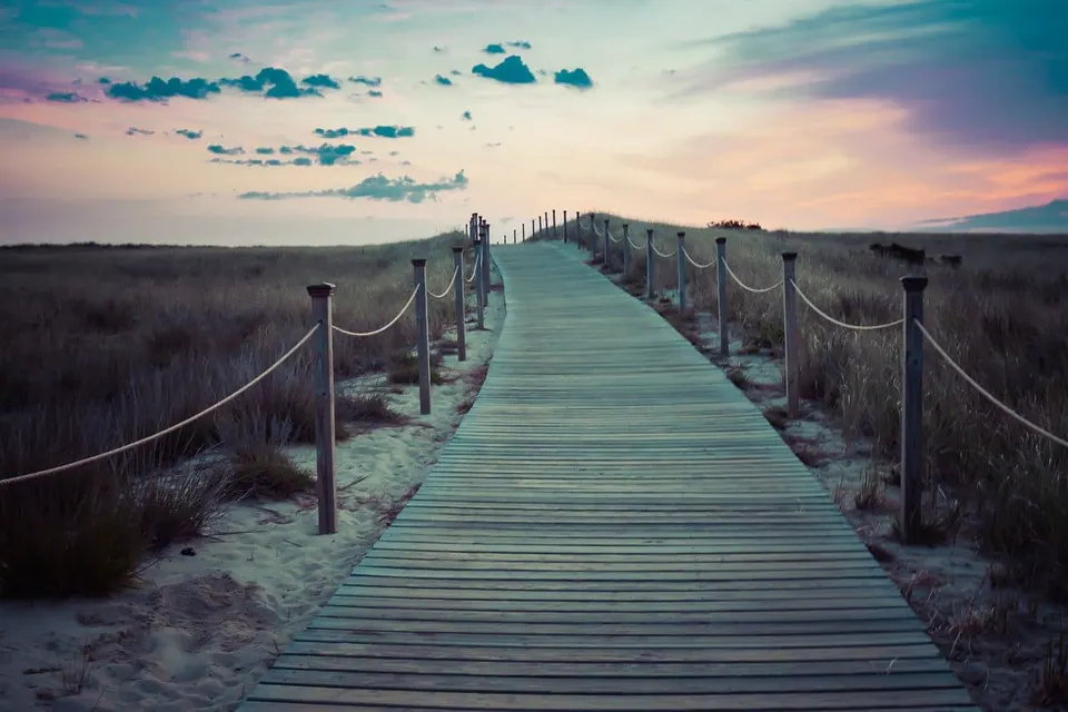 Chemin de planches à travers les dunes, vers l'horizon