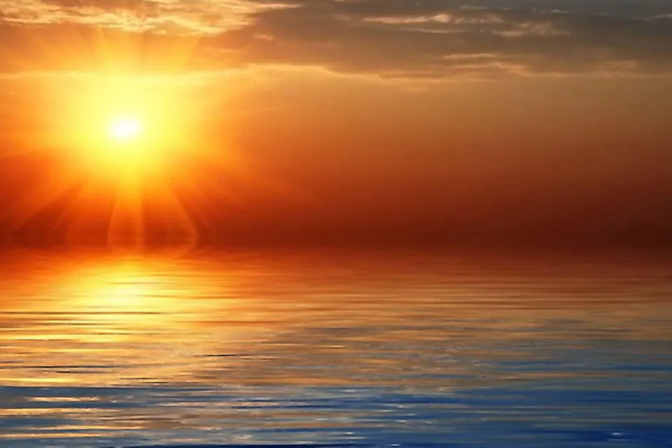 Soleil couchant sur une mer calme aux reflets dorés